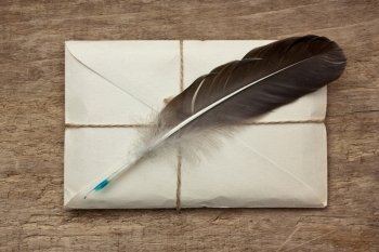 letter and a quill  on a wooden background