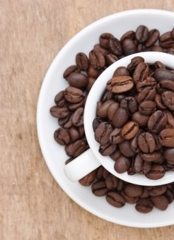 coffee beans in a cup on a wooden background