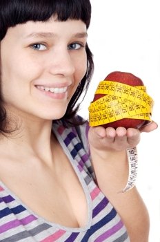 attractive girl with apple and tape measure in the hand a over white background