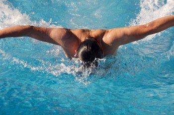 photo of a swimmer doing spring in swimming pool