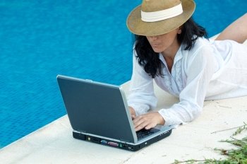 Woman working comfortably on the swimming pool