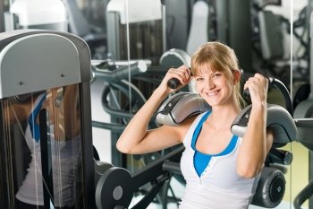 Fitness center young woman exercise abdominal muscles on gym machine