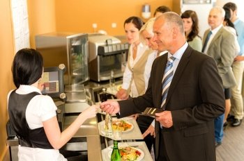 Cafeteria man pay by credit card cashier food on serving tray
