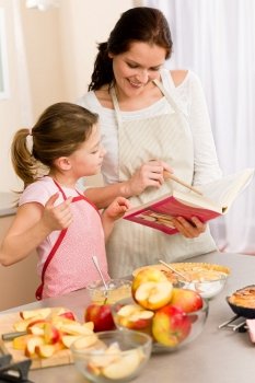 Apple pie mother and daughter follow recipe from baking cookbook