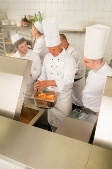 Professional chef cook with team prepare food in industrial kitchen