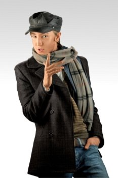 A portrait of a young handsome man wearing jacket, scarf and hat.