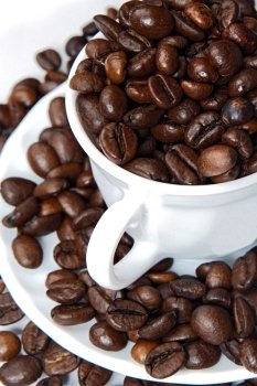 Coffee beans in a white cup overflows