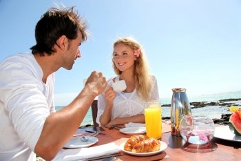 Couple having breakfast by blue lagoon