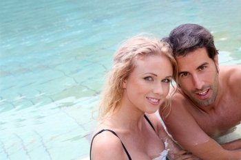Portrait of couple in resort swimming pool