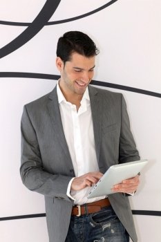 Young relaxed man using electronic tablet