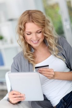 Blond woman doing online shopping with digital tablet
