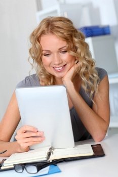 Beautiful woman in office using digital tablet