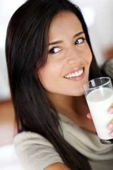 Attractive young woman drinking fresh milk