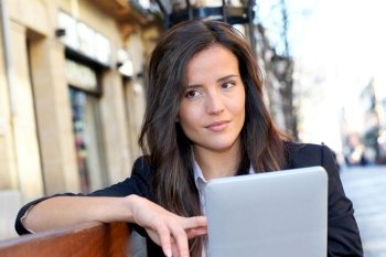 Woman sitting on public bench with tablet
