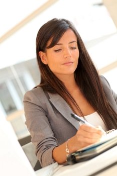 Portrait of beautiful businesswoman writing notes on agenda