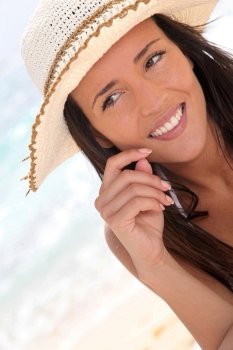 Closeup of woman at the beach with straw hat