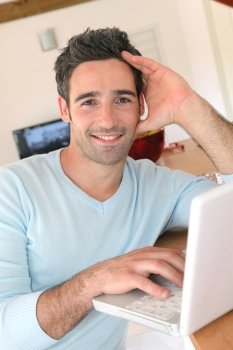 Man at home connected on internet with laptop