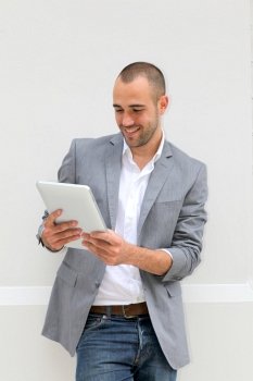 Cool businessman using electronic tablet on white background