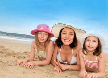 Mother and daughters lying down the beach