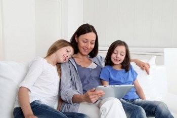 Mother and girls using electronic tablet at home