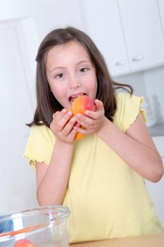 Portrait of little girl eating apricots