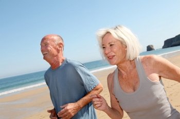 Senior couple jogging on a sandy beach