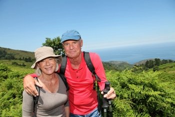 Portrait of happy senior couple hiking in natural landscape
