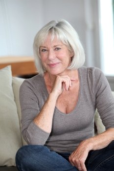 Portrait of smiling senior woman sitting in sofa
