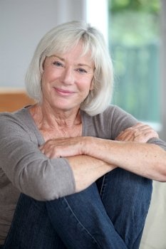 Portrait of smiling senior woman sitting in sofa