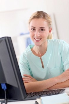 Portrait of beautiful nurse in front of desktop