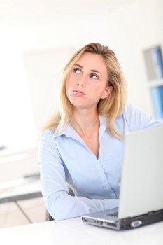 Blond woman at work with thoughtful look