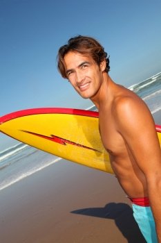 Portrait of handsome surfer at the beach