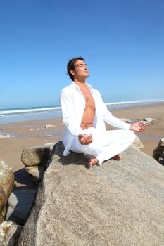 Man doing meditation exercises on the beach