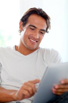 Smiling man using touchpad at home