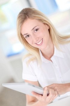 Portrait of blond woman using electronic tablet