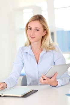 Office worker sitting at table with agenda and touchpad