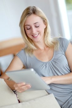 Young woman using electronic tablet in sofa