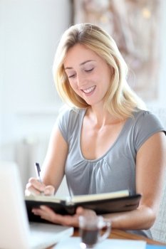 Beautiful woman working at home on agenda