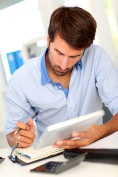 Portrait of office worker using electronic tablet