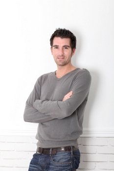 Man with arms crossed standing on white background
