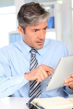 Manager in office using electronic tablet
