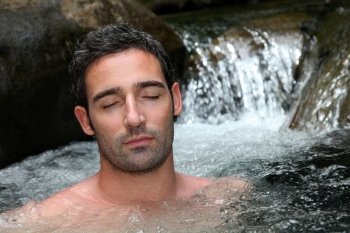 Closeup of man relaxing in natural river spa