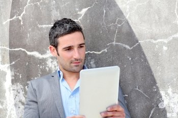 Businessman using electronic tablet outside the office
