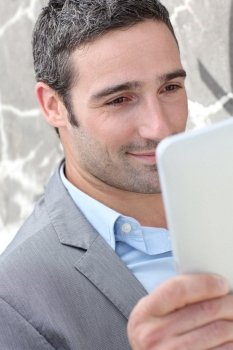 Businessman using electronic tablet outside the office