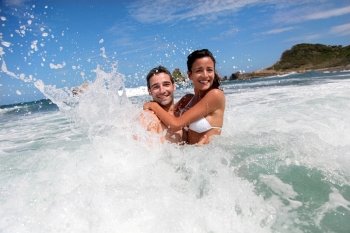 Cheerful couple enjoying the waves