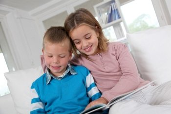 Children reading book at home