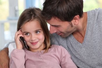 Father and little girl using mobile phone