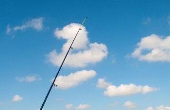 Vertical fishing rod against the blue sky