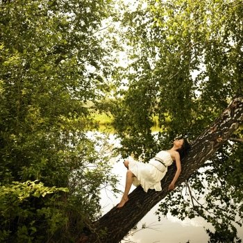 Fashion portrait of young fine woman on tree