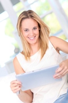 Young woman at home using electronic tablet